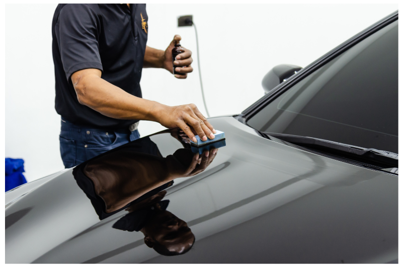 picture of man applying ceramic coating on black car