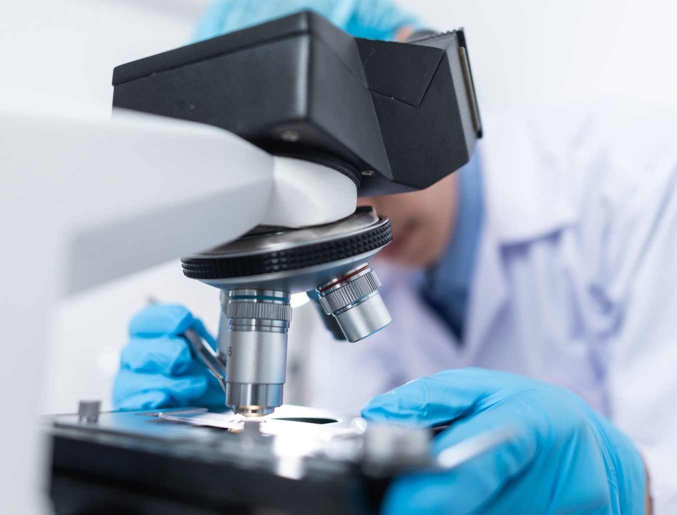 picture of man in lab coat looking at microscope