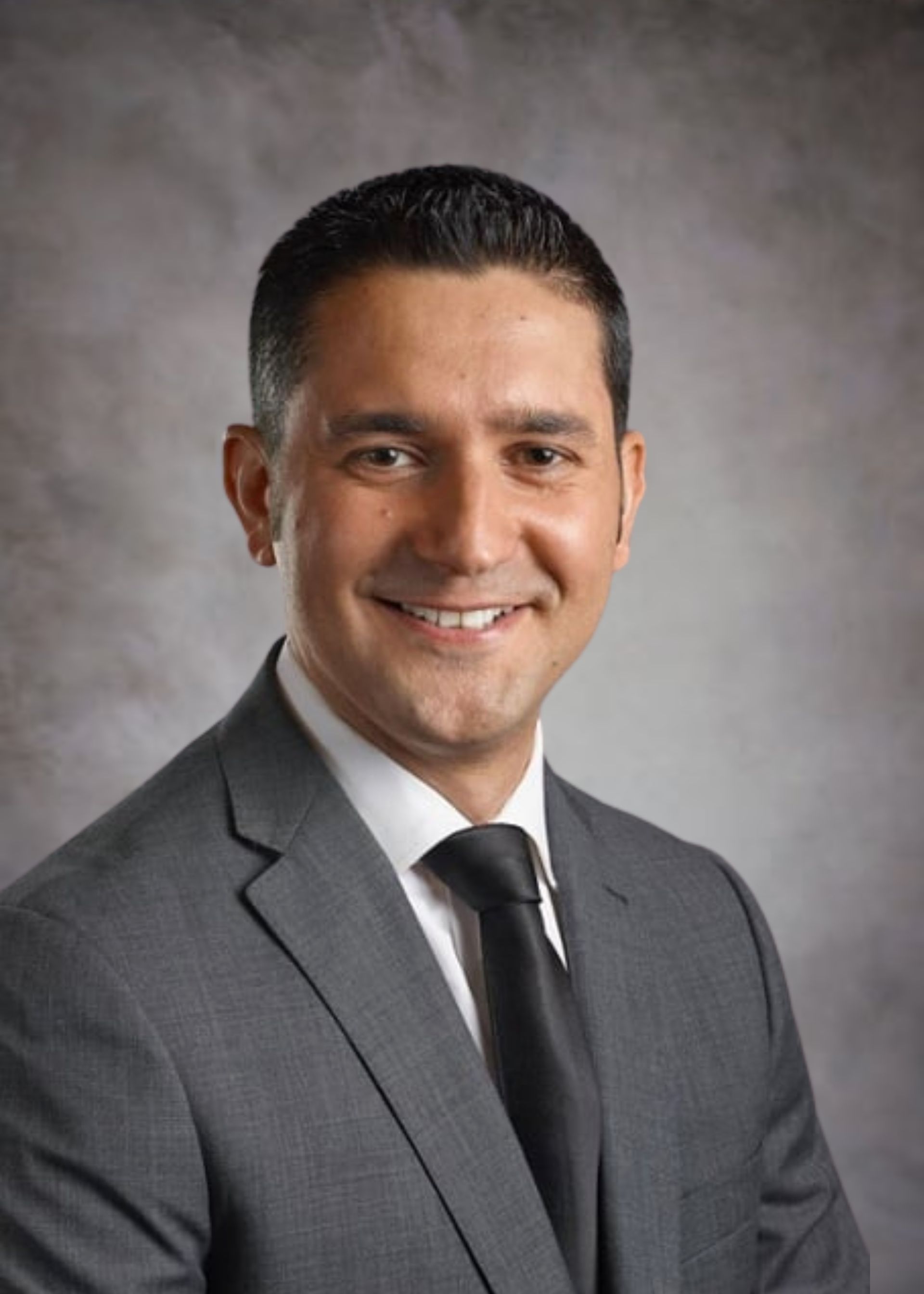 A man in a suit and tie is smiling for the camera.