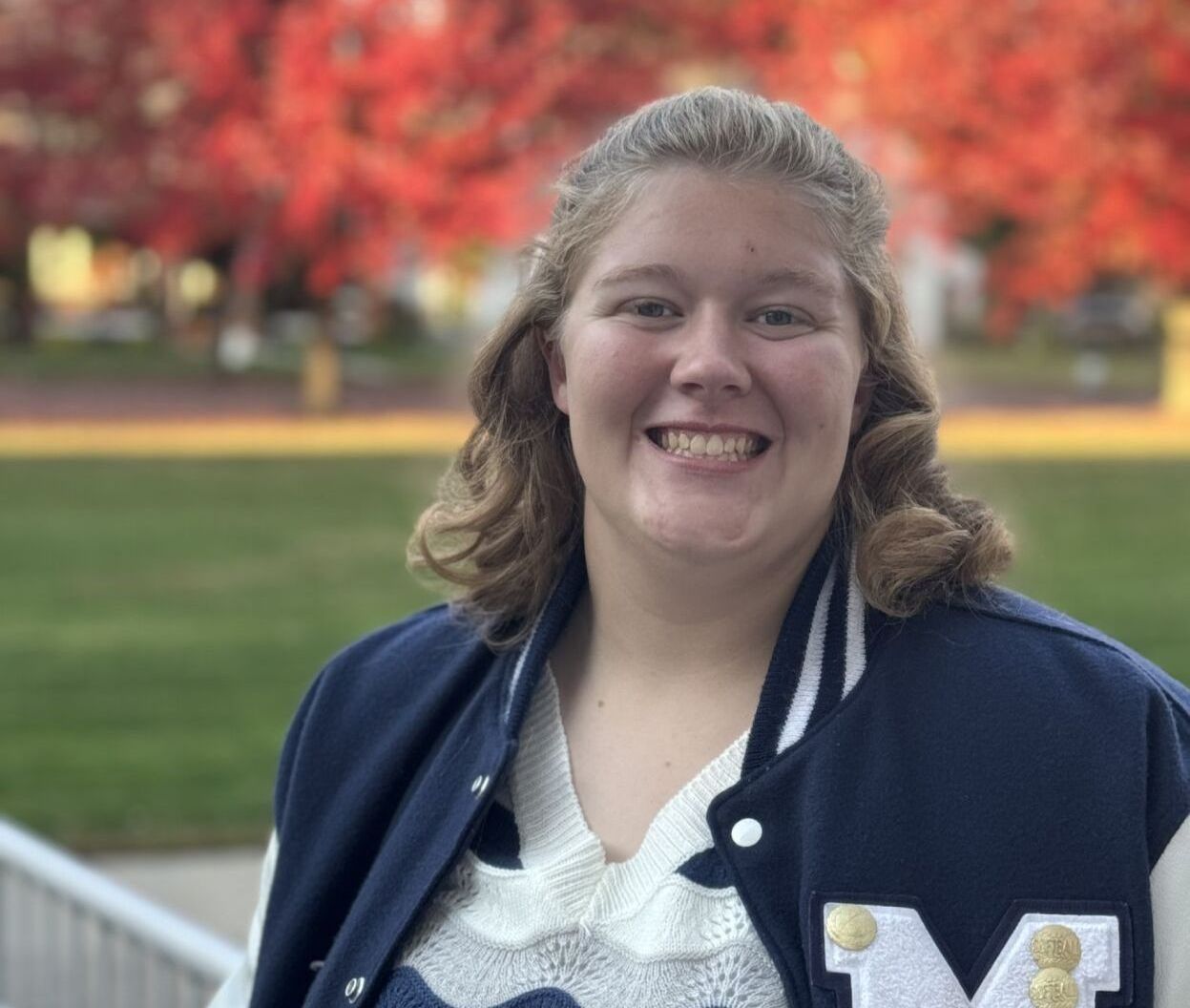 A woman wearing a blue jacket with the letter m on it