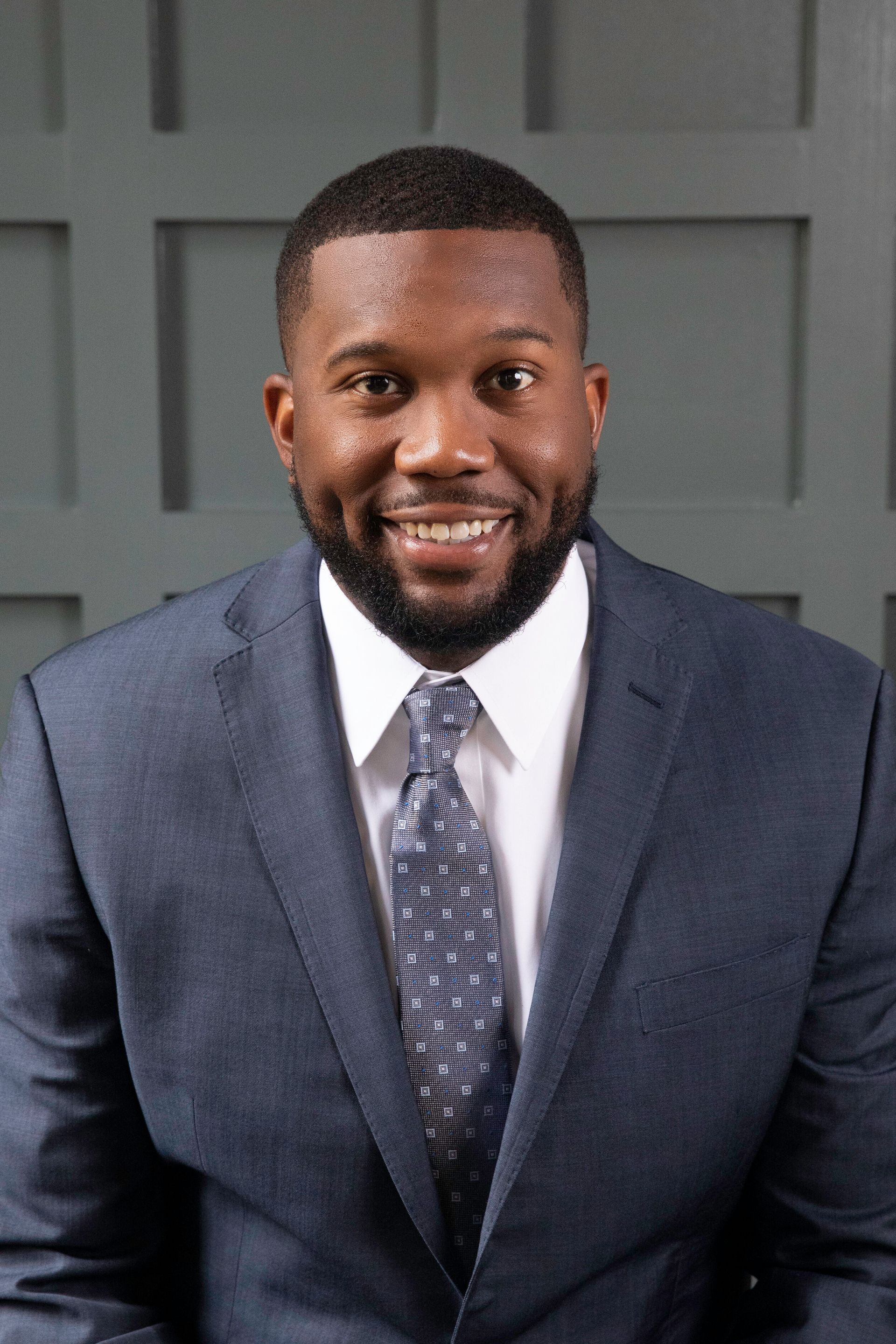 A man in a suit and tie is smiling for the camera.