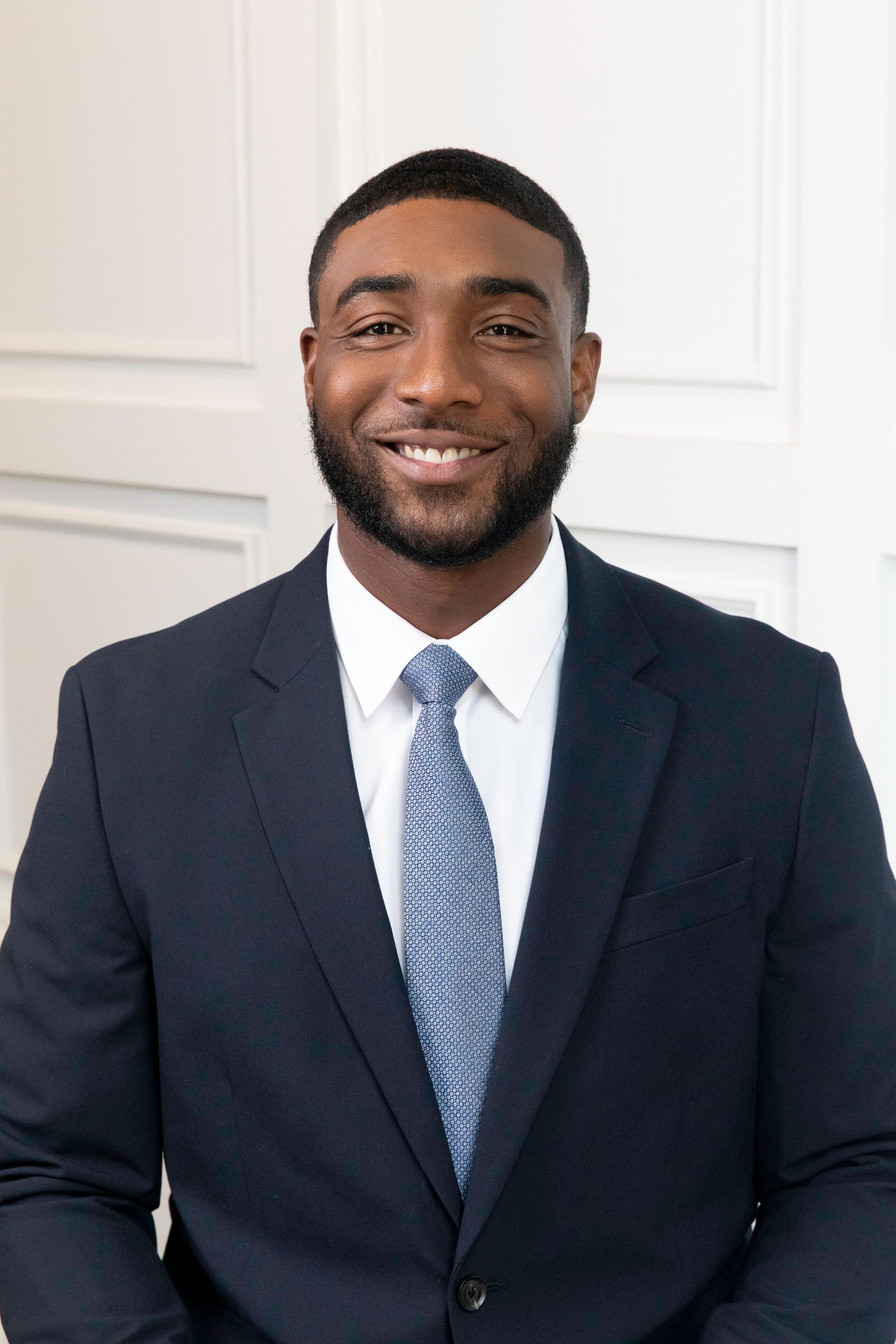 A man in a suit and tie is smiling for the camera.