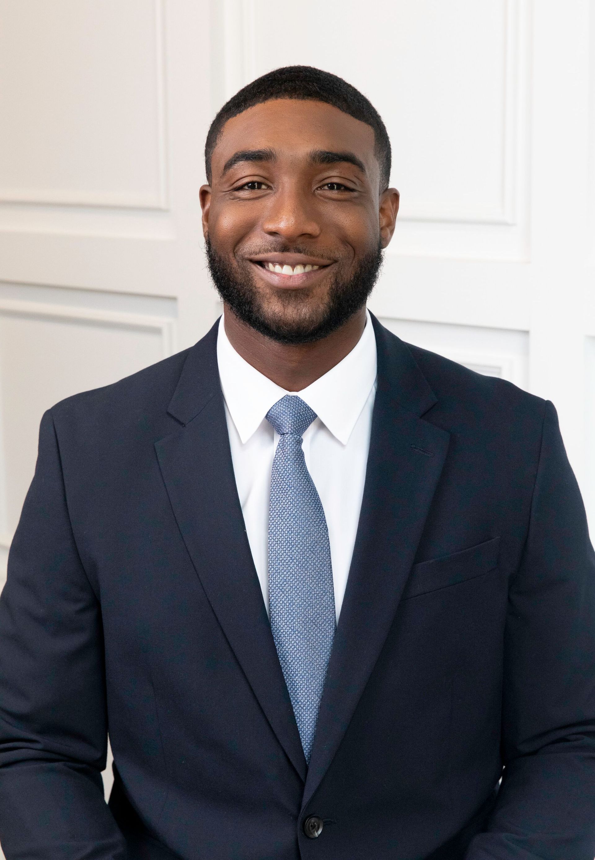 A man in a suit and tie is smiling for the camera.