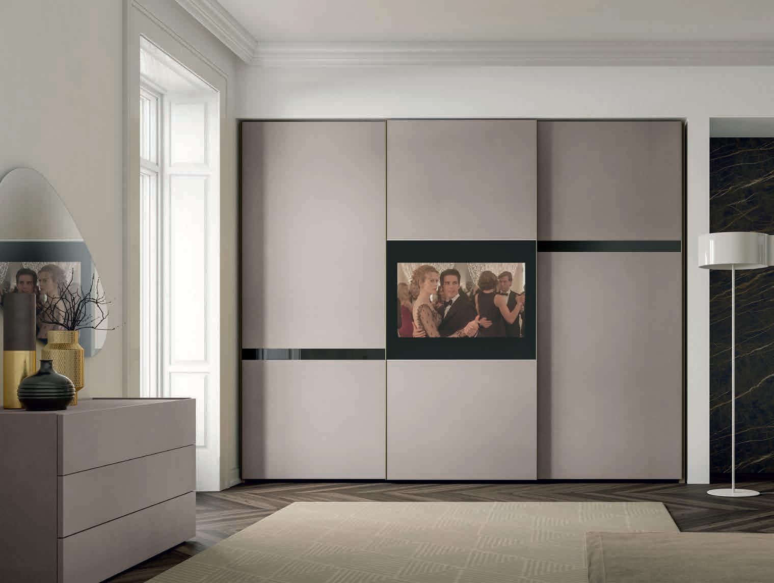 Una camera da letto con porte scorrevoli e una TV a schermo piatto sulla parete