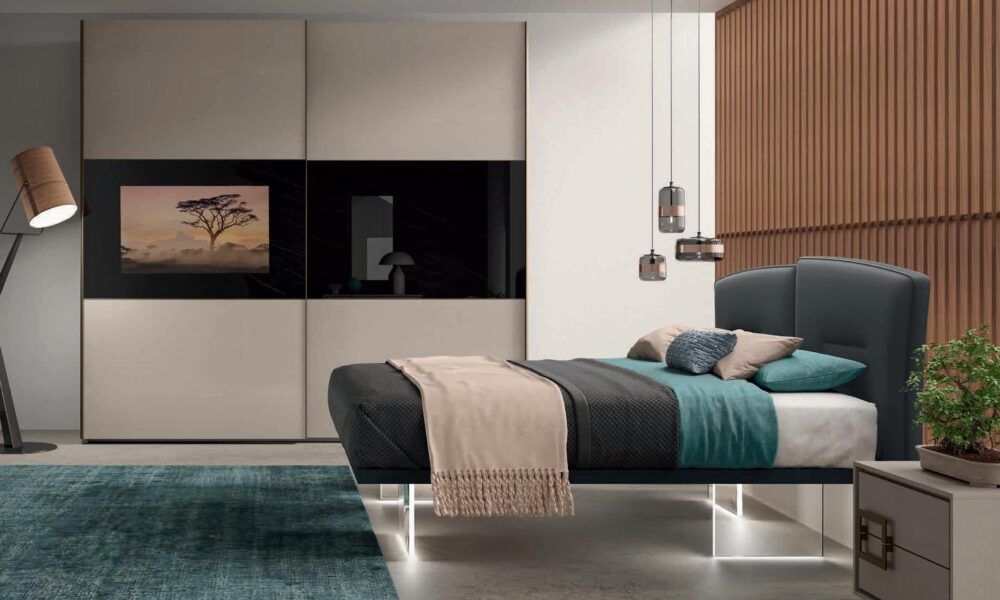 Una camera da letto con un letto e una tv sul muro