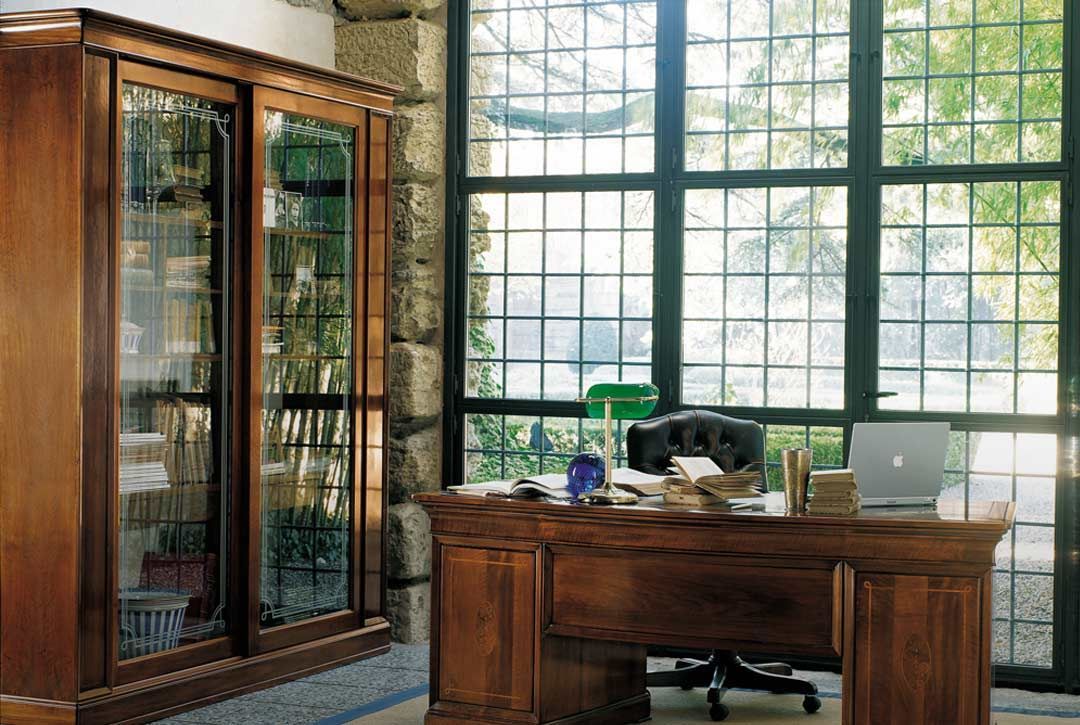 Una scrivania di legno davanti a una grande finestra
