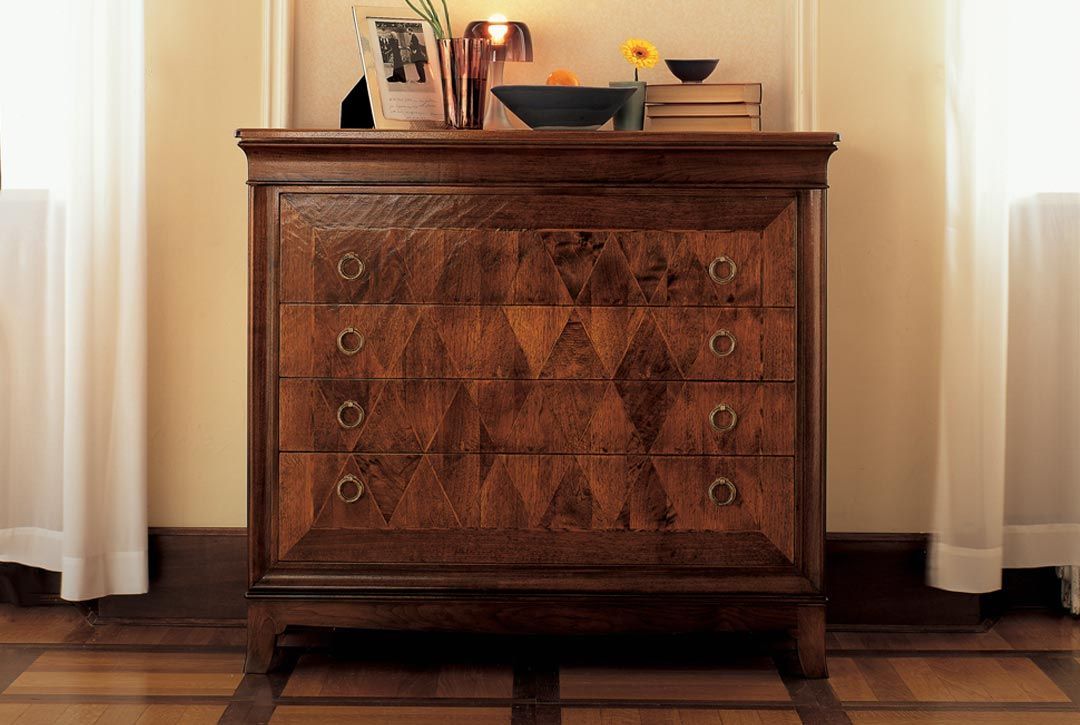 Una cassettiera di legno in una stanza accanto a una finestra