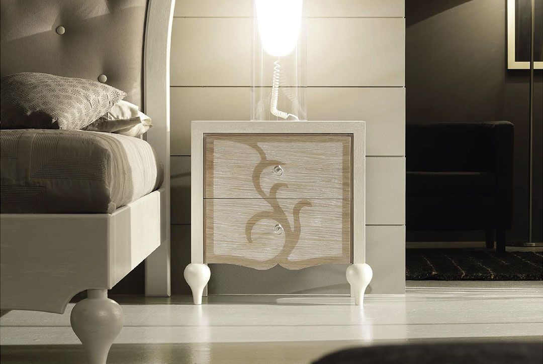 Un comodino in una camera da letto accanto a un letto