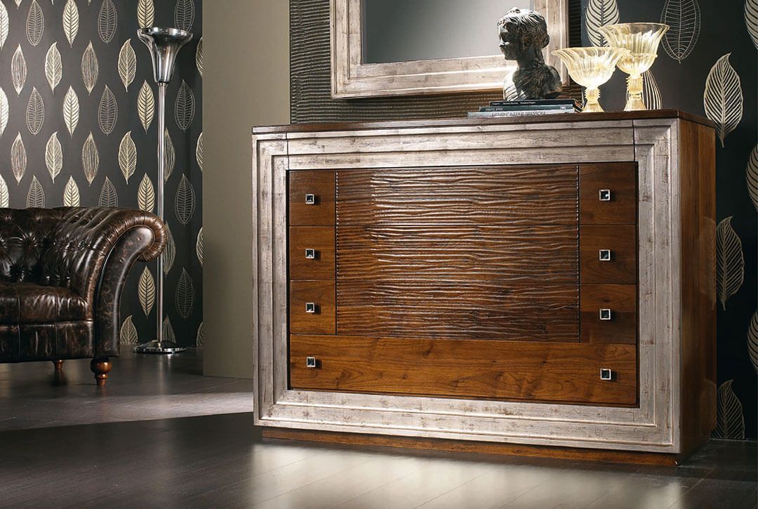 Una stanza con una cassettiera, una sedia e uno specchio