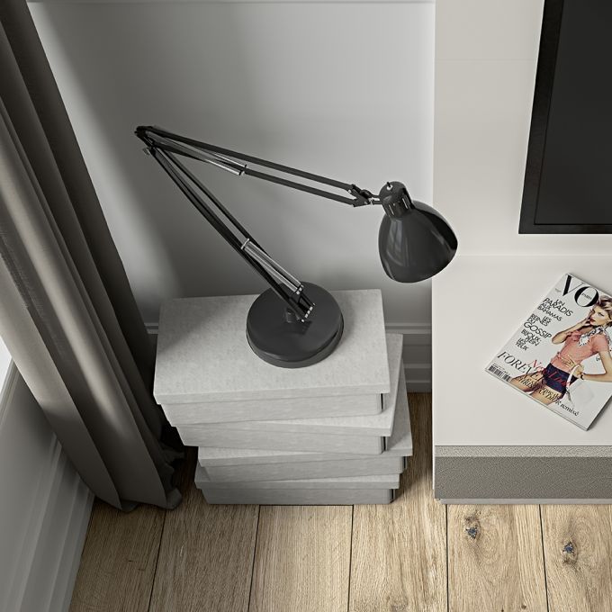 Una lampada è appoggiata su una pila di libri accanto a una rivista