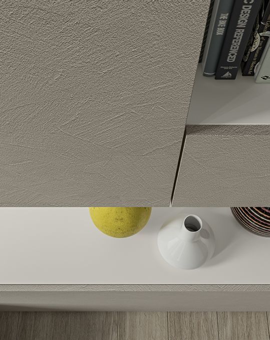 Un vaso bianco è appoggiato su uno scaffale accanto a un limone