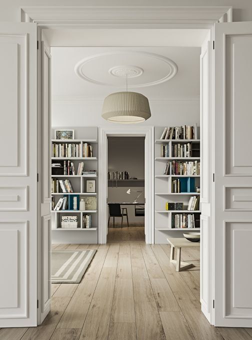 Un corridoio con librerie e una lampada appesa al soffitto