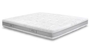 Un materasso bianco è appoggiato su una superficie bianca.