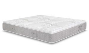 Un materasso bianco è appoggiato su una superficie bianca.