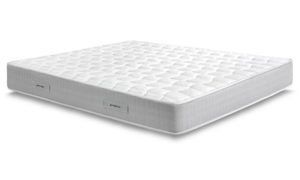 Un materasso bianco è appoggiato su una superficie bianca.