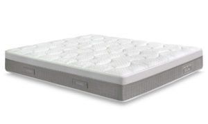 Un materasso bianco è appoggiato su una superficie bianca.