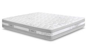 Un materasso bianco è appoggiato su una superficie bianca.