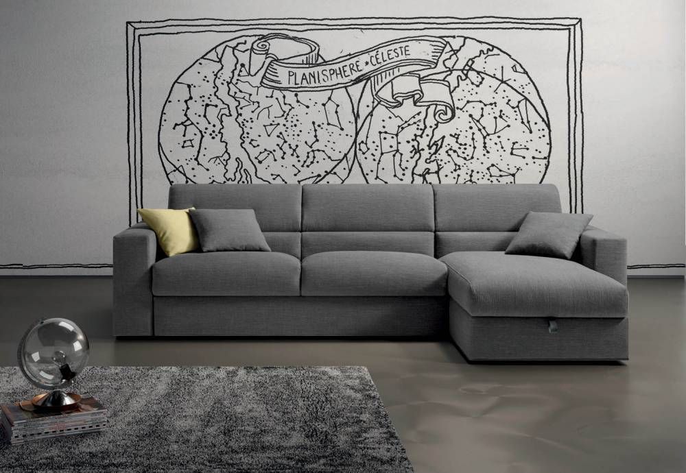 Un divano componibile grigio in un soggiorno con un quadro sulla parete dietro