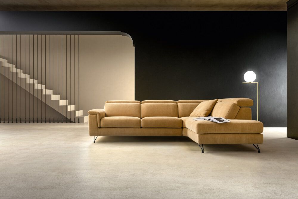 Un soggiorno con un grande divano componibile e scale