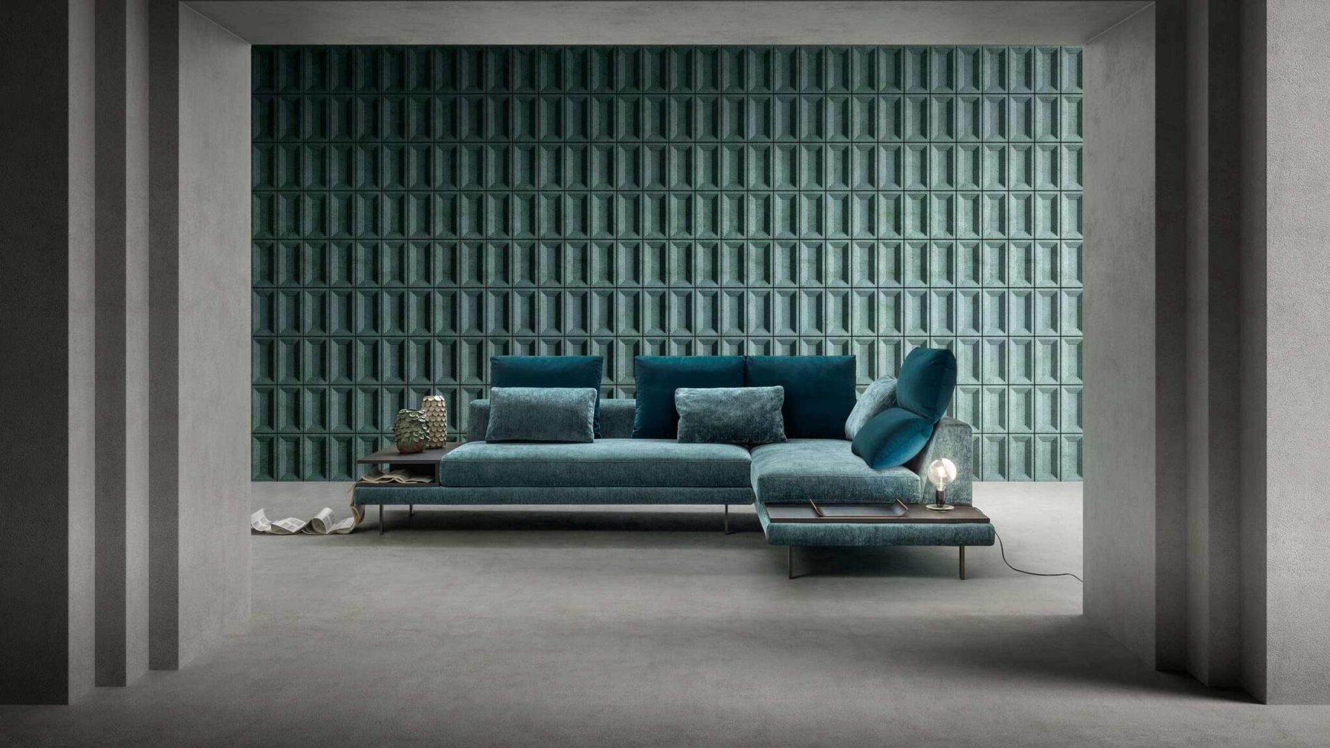 Un divano componibile blu è appoggiato di fronte a una parete verde