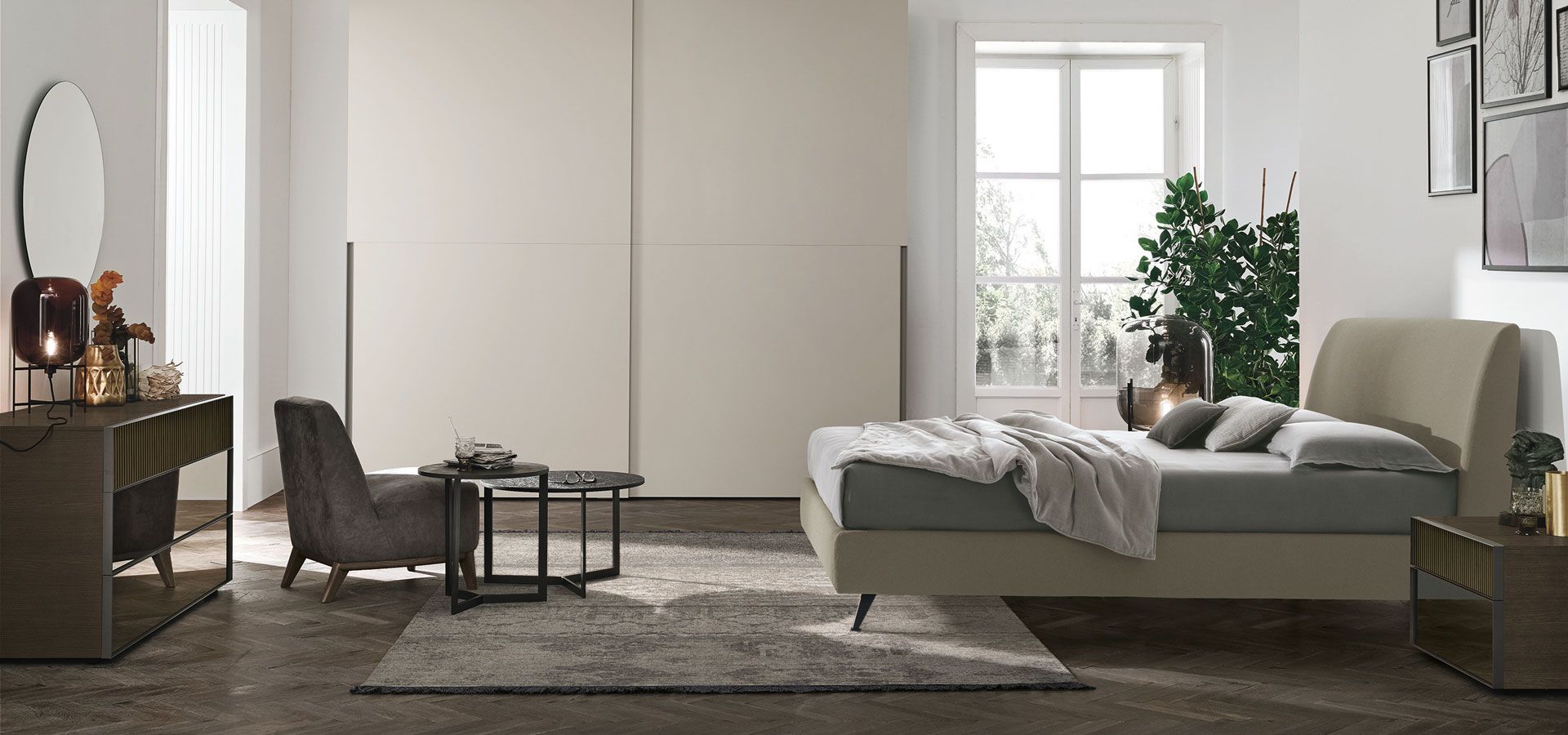 Una camera da letto con un letto, una sedia, una cassettiera e uno specchio