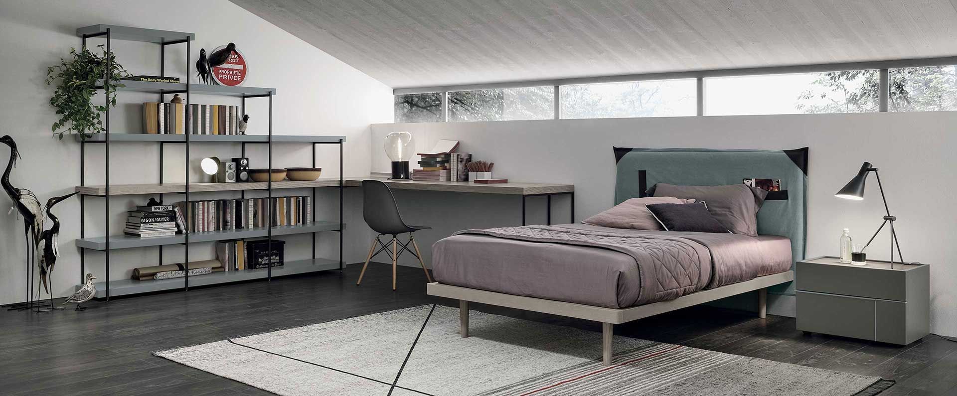 Una camera da letto con un letto, una scrivania, un comodino e un tappeto