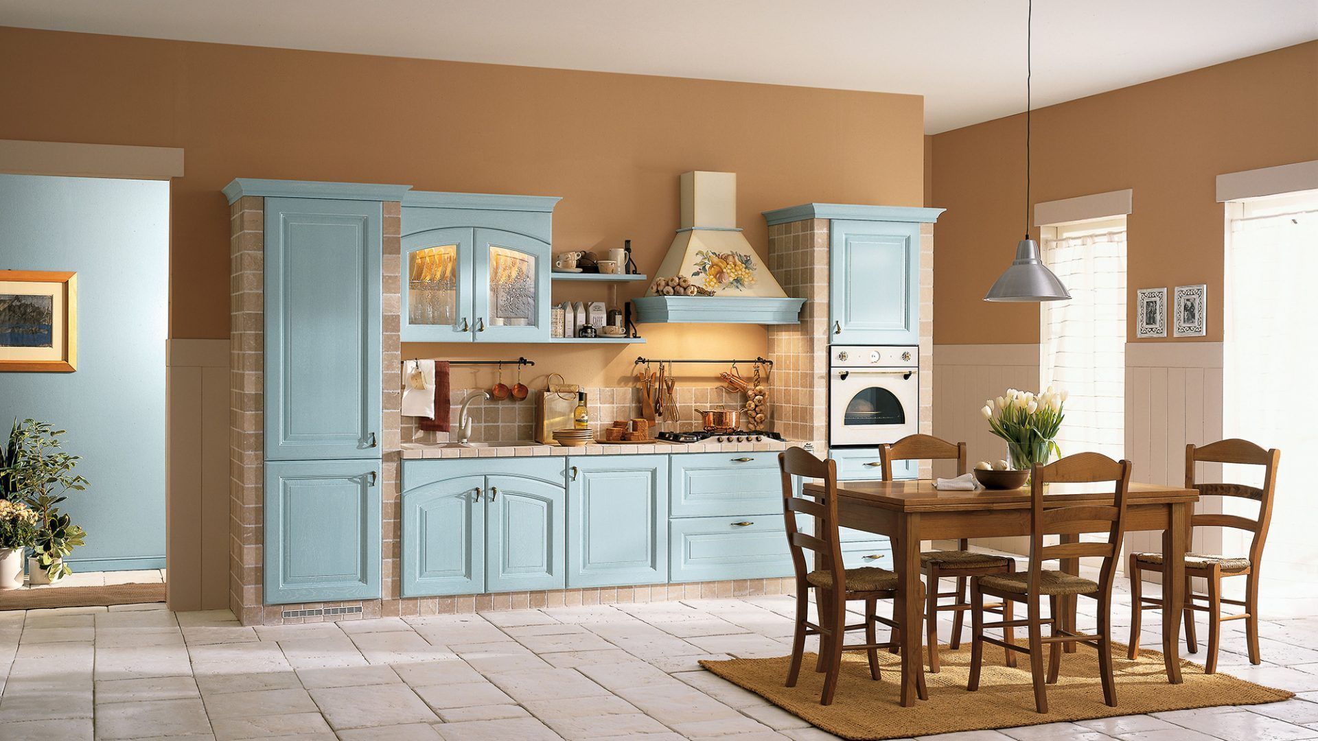 Una cucina con mobili blu, tavolo e sedie