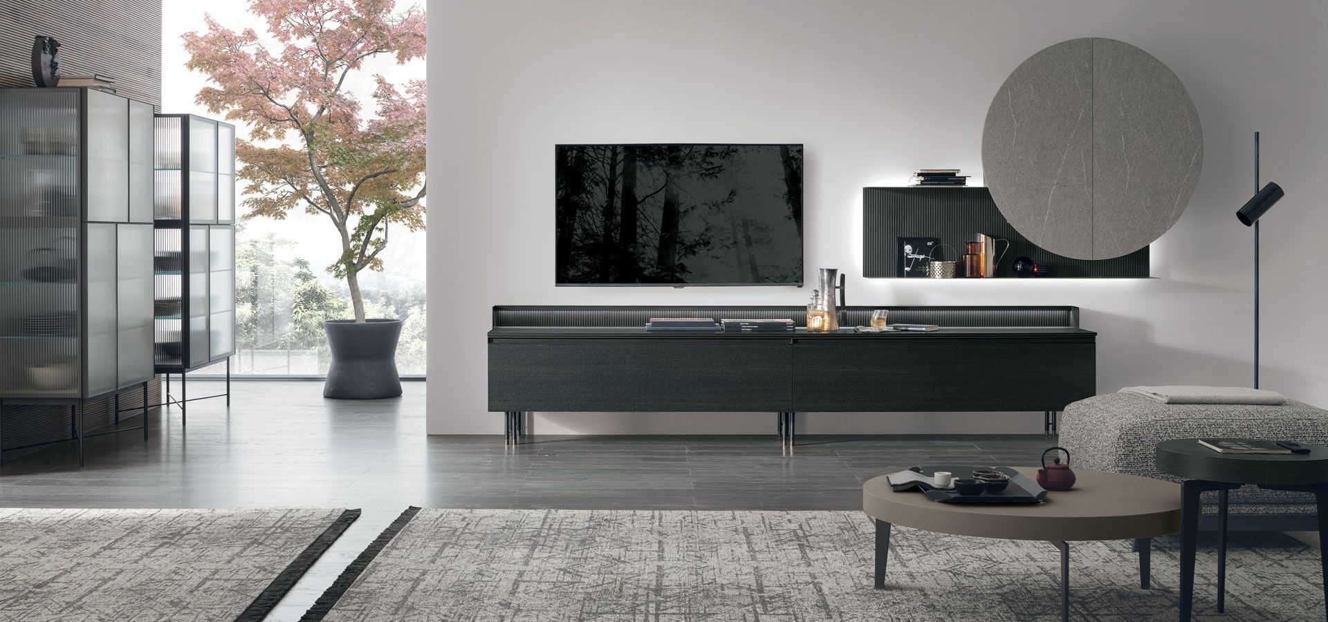 Un soggiorno con una tv nera sul muro