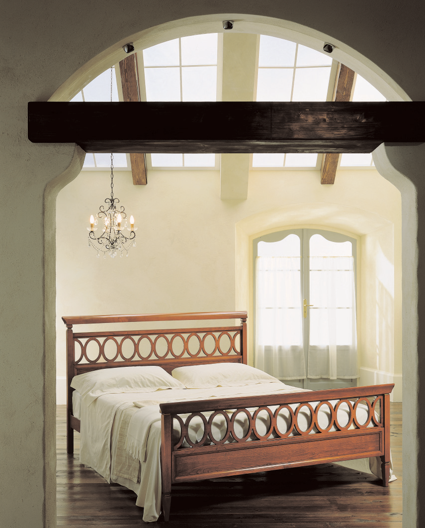 Una camera da letto con un letto e un lampadario appeso al soffitto