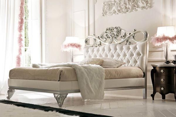 Una camera da letto con un letto bianco e un comodino