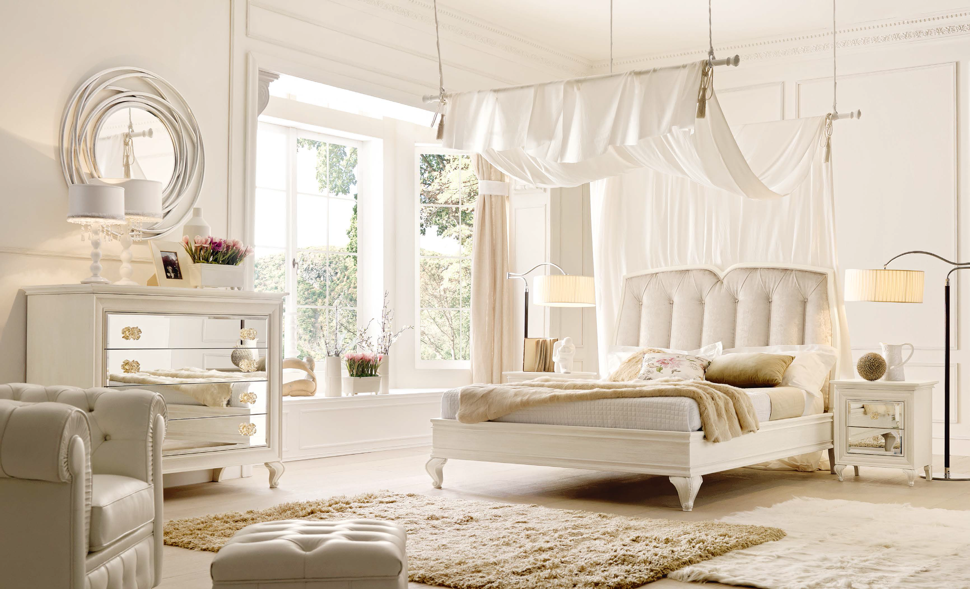 Una camera da letto con mobili bianchi e un letto a baldacchino