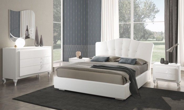 Una camera da letto con un letto, una cassettiera, un comodino e uno specchio