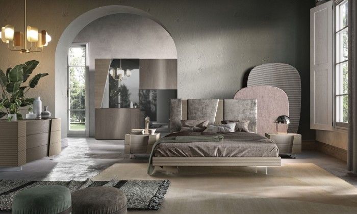 Una camera da letto con letto, cassettiera, comodino e lampadario.