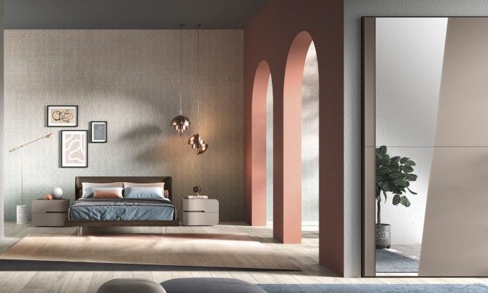 Una camera da letto con un letto, comodini e un grande specchio.