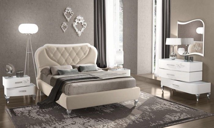 Una camera da letto con letto, cassettiera, comodino e specchio.