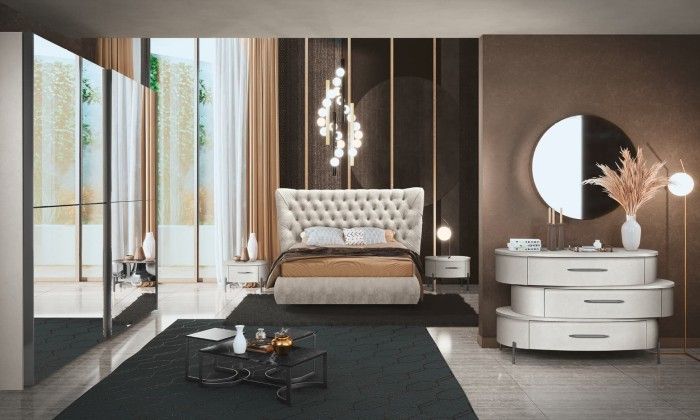 Una camera da letto con letto, cassettiera, comodino e specchio.