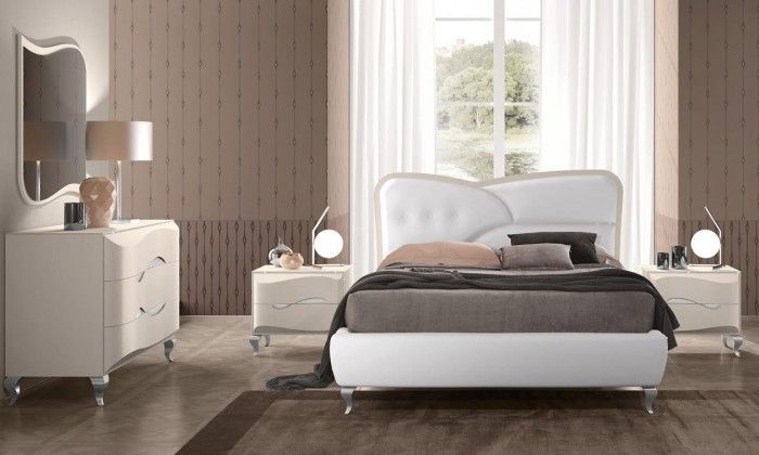 Una camera da letto con letto, cassettiera, comodino e specchio.