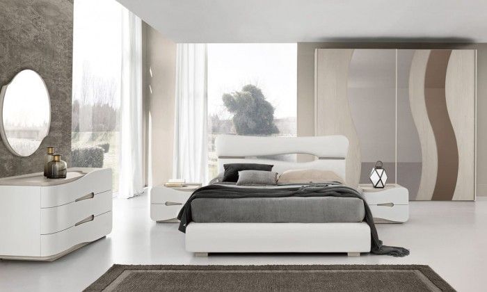 Una camera da letto con un letto, una cassettiera, un comodino, uno specchio e un tappeto.