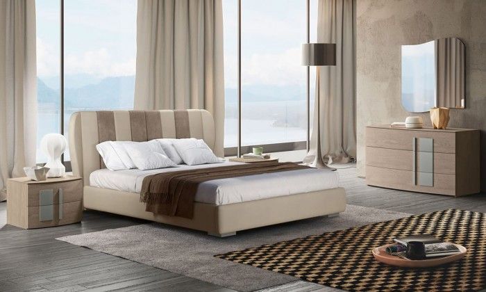 Una camera da letto con un letto, una cassettiera, un comodino, uno specchio e un tappeto.