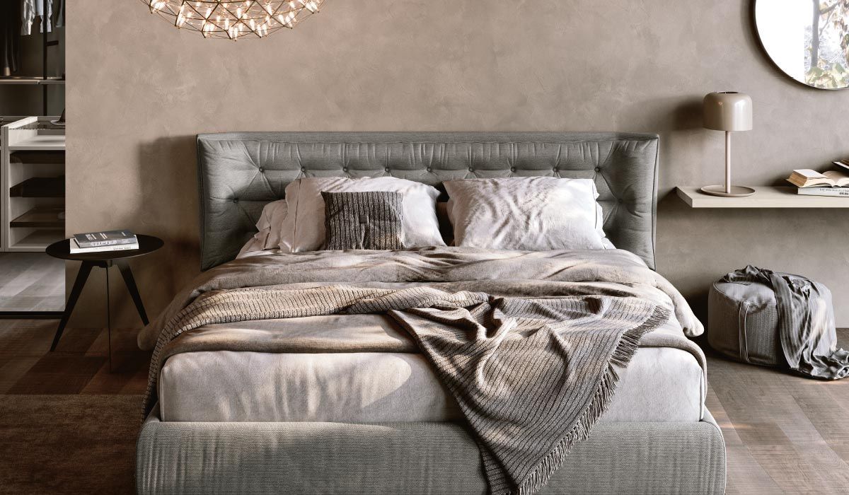 Una camera da letto con letto, comodino, specchio e lampadario.