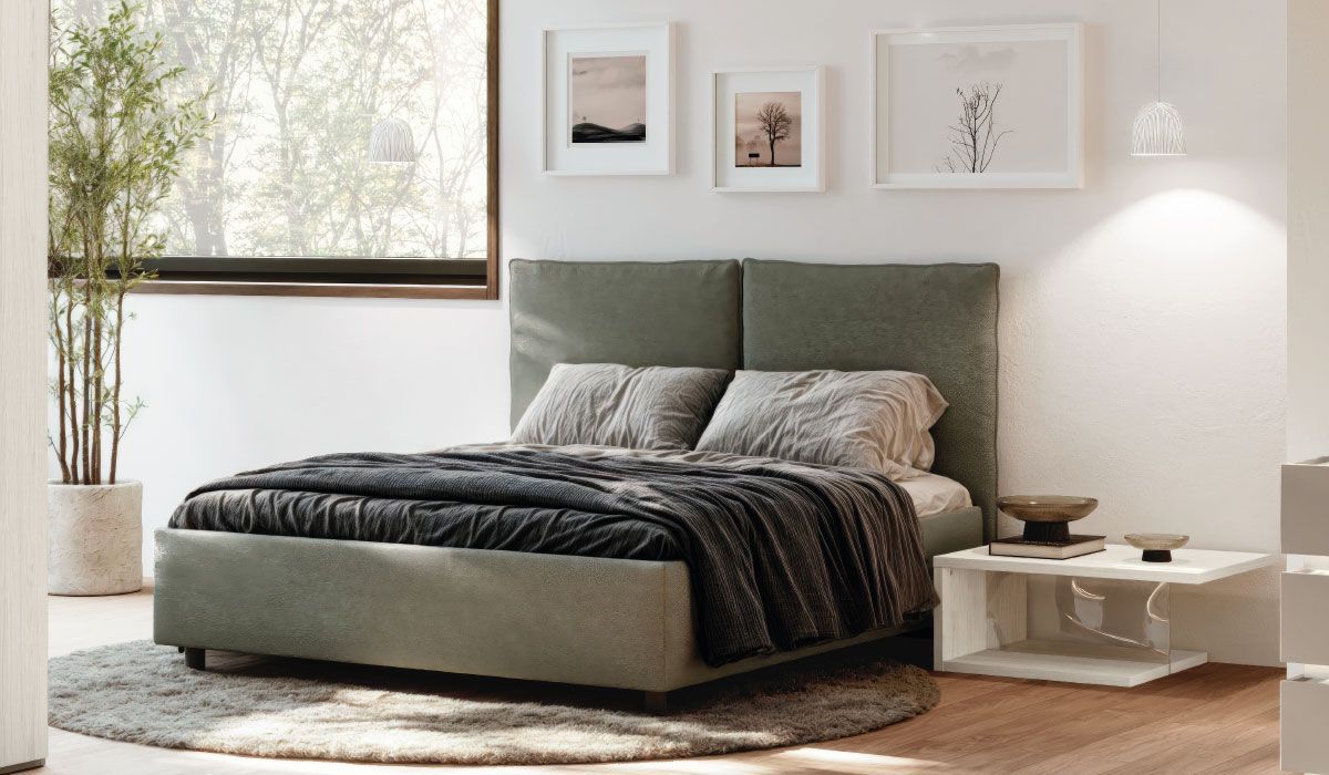 Una camera da letto con un letto, un tavolo, una pianta e una finestra.