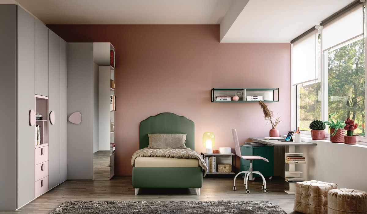 Una camera da letto con un letto verde e una scrivania