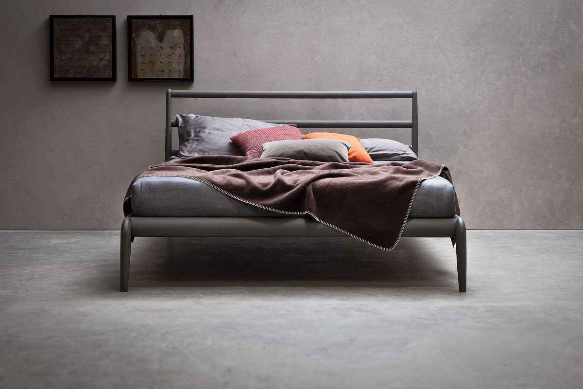 Un letto con una coperta marrone e dei cuscini sopra