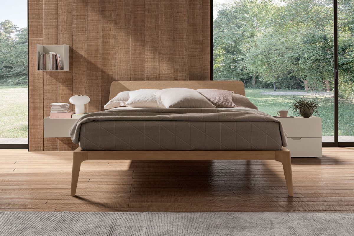 Una camera da letto con un letto e una finestra con alberi sullo sfondo