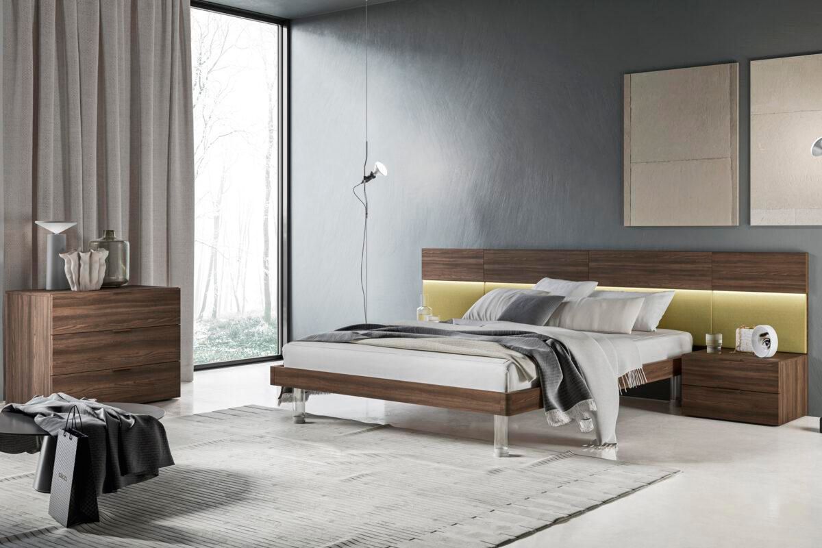 Una camera da letto con un letto, una cassettiera e un comodino