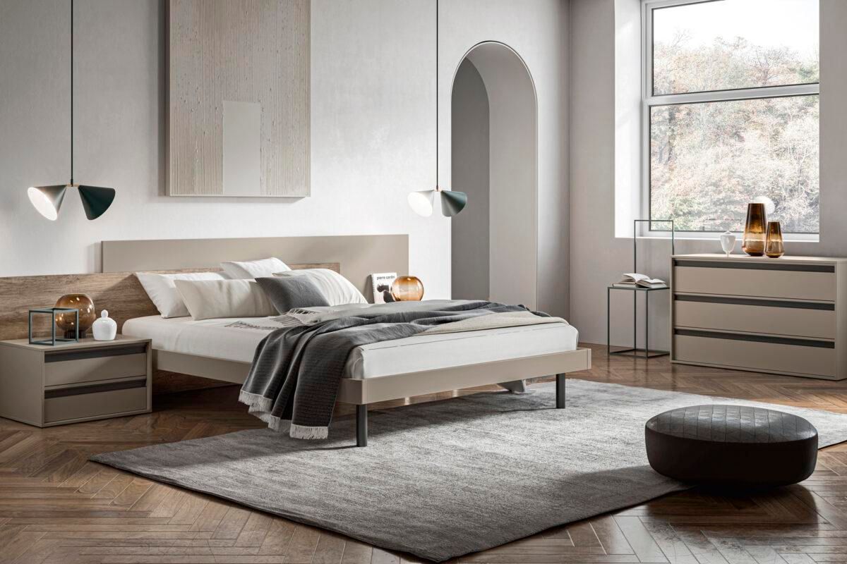 Una camera da letto con un letto, un comodino, una cassettiera e un tappeto.