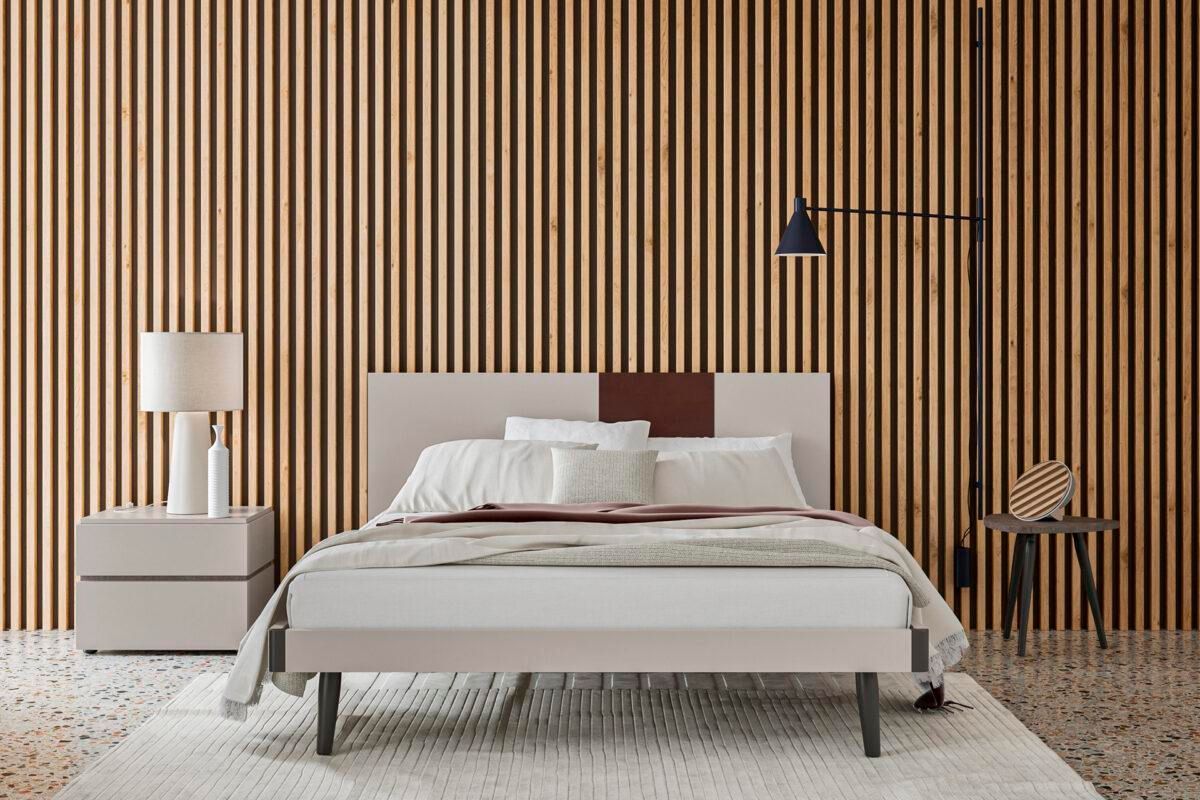 Una camera da letto con un letto, un comodino, una lampada e una parete a strisce.