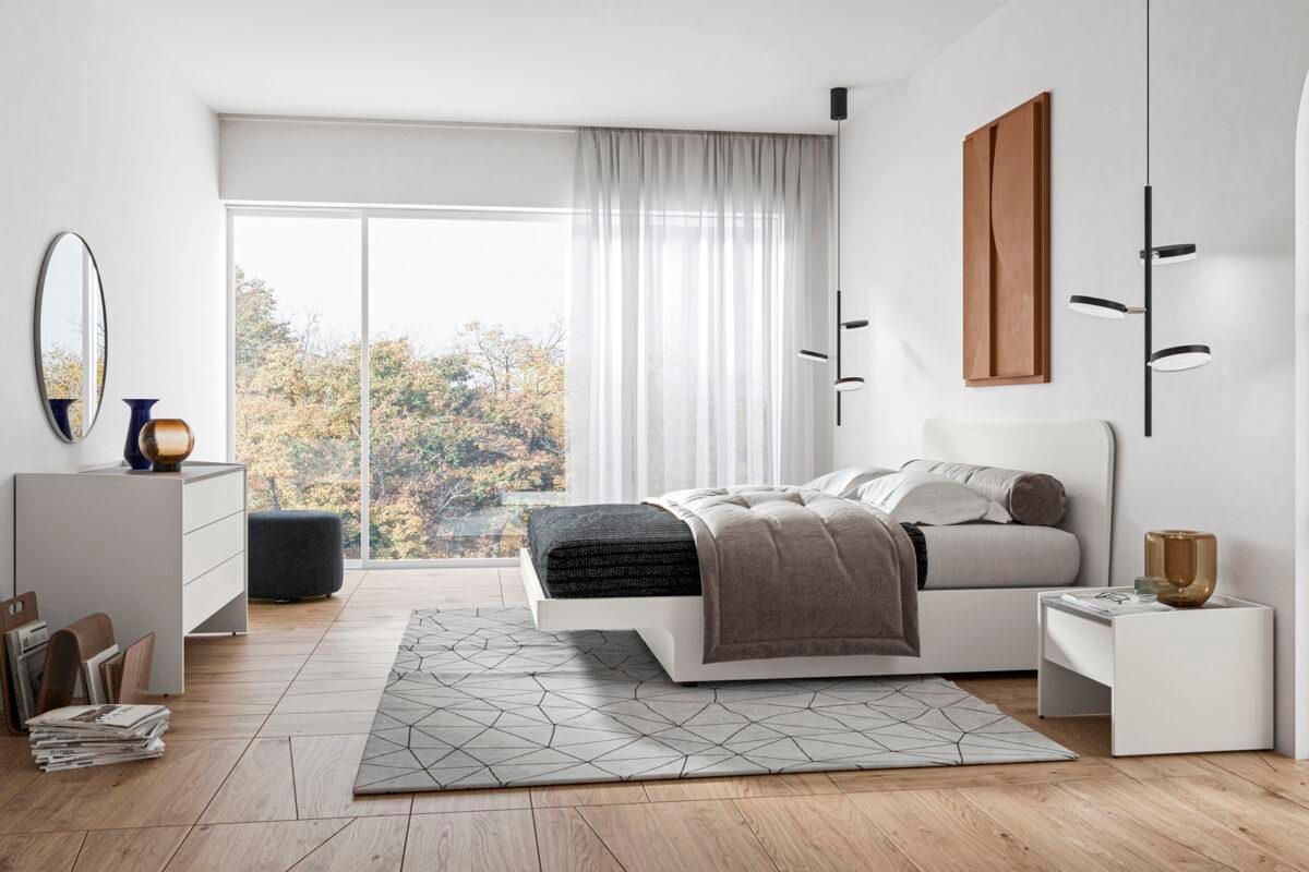 Una camera da letto con un letto, una cassettiera, un comodino e uno specchio