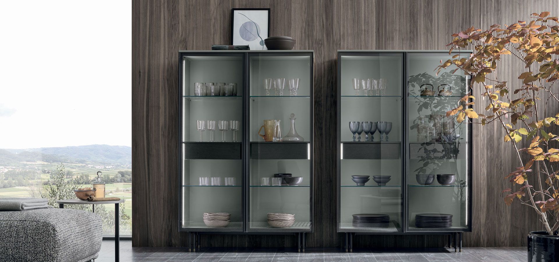 Un soggiorno con tre vetrine piene di bicchieri e ciotole.