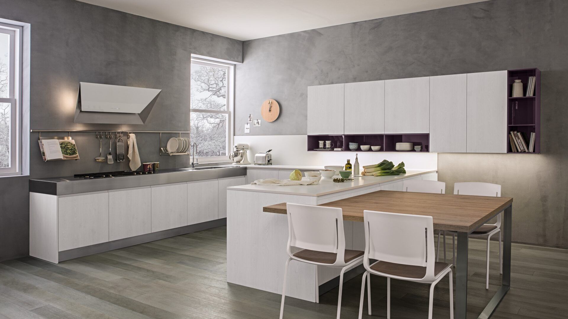 Una cucina con mobili bianchi e un tavolo di legno